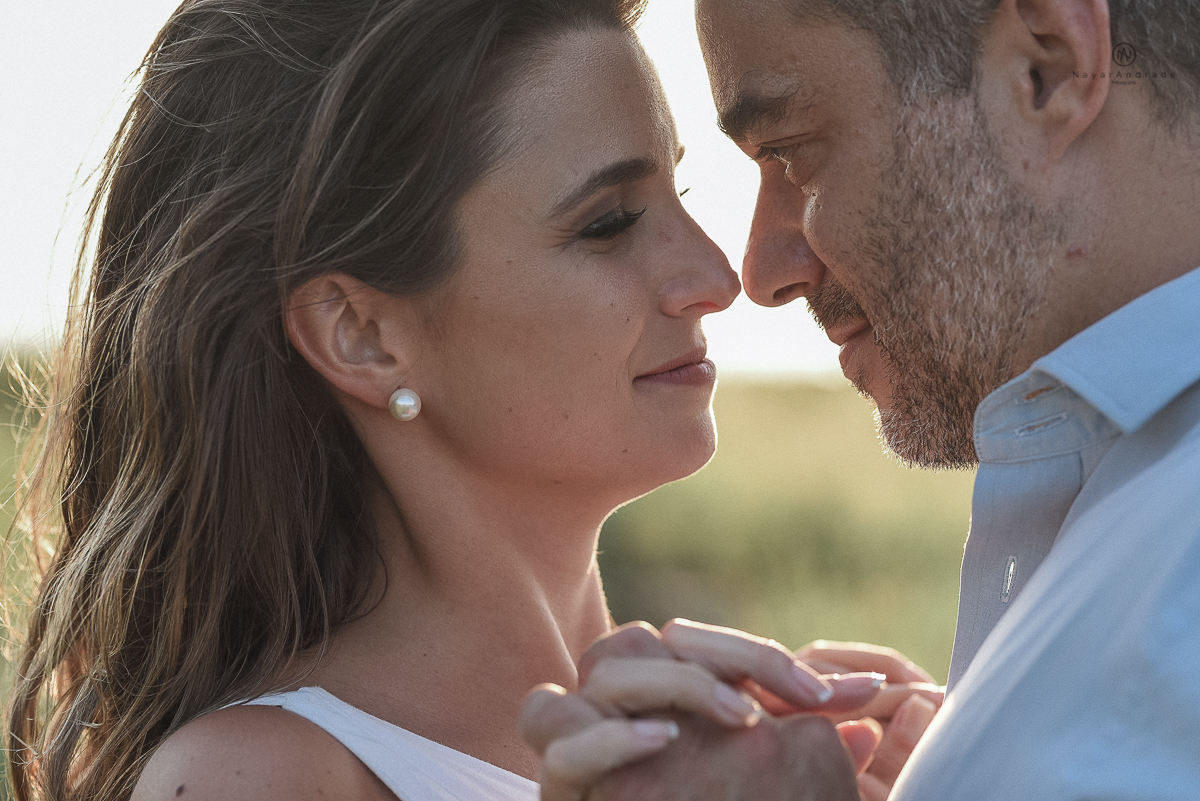 ensaio feito no fim de tarde na praia com a golden hour lindos raios de sol e luz natural casal romantico e apaixonado