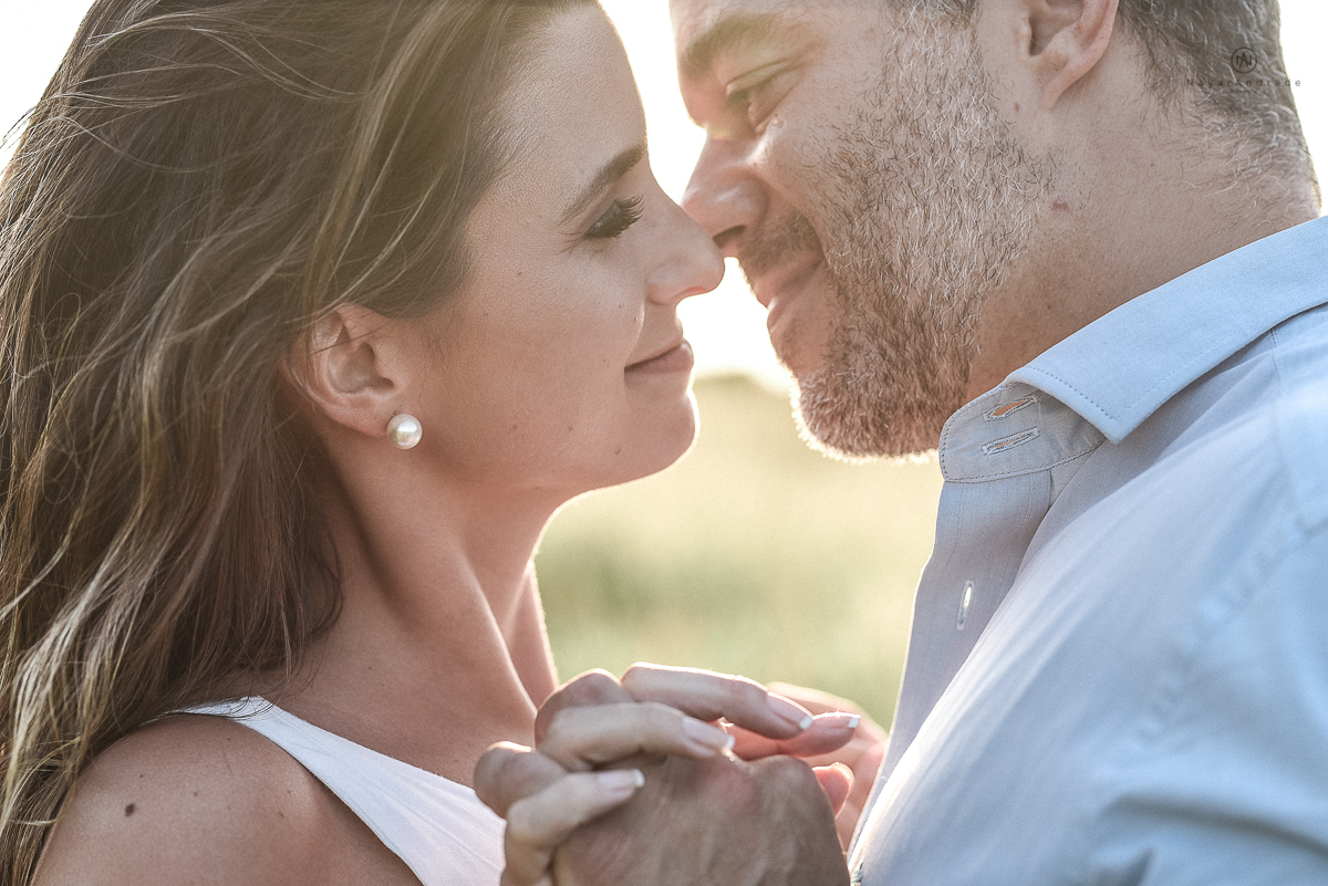 ensaio feito no fim de tarde na praia com a golden hour lindos raios de sol e luz natural casal romantico e apaixonado