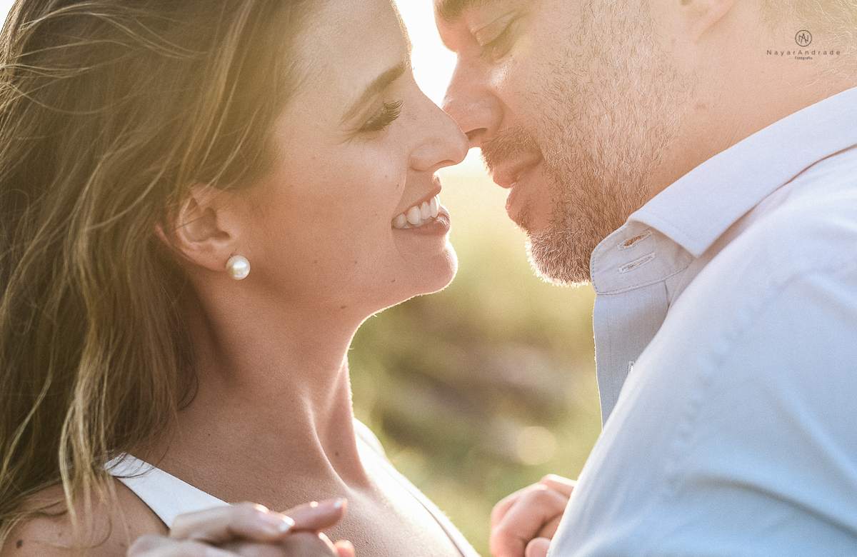 ensaio feito no fim de tarde na praia com a golden hour lindos raios de sol e luz natural casal romantico e apaixonado
