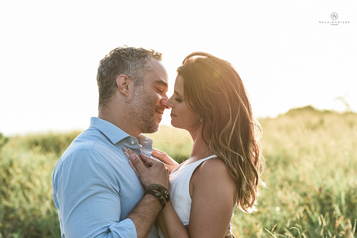 ensaio feito no fim de tarde na praia com a golden hour lindos raios de sol e luz natural casal romantico e apaixonado