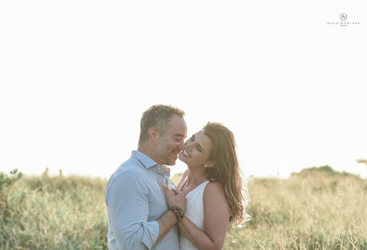 ensaio feito no fim de tarde na praia com a golden hour lindos raios de sol e luz natural casal romantico e apaixonado