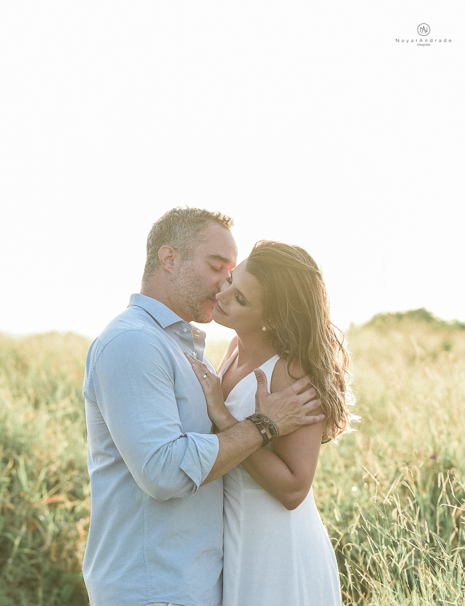 ensaio feito no fim de tarde na praia com a golden hour lindos raios de sol e luz natural casal romantico e apaixonado