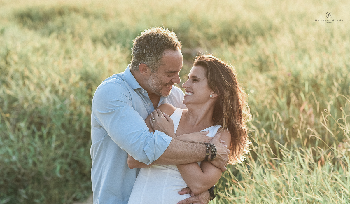 ensaio feito no fim de tarde na praia com a golden hour lindos raios de sol e luz natural casal romantico e apaixonado