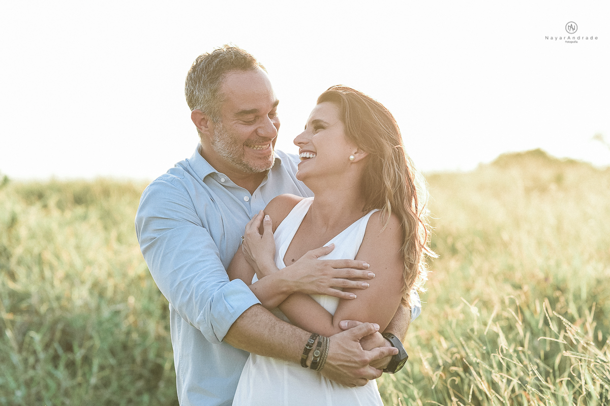ensaio feito no fim de tarde na praia com a golden hour lindos raios de sol e luz natural casal romantico e apaixonado