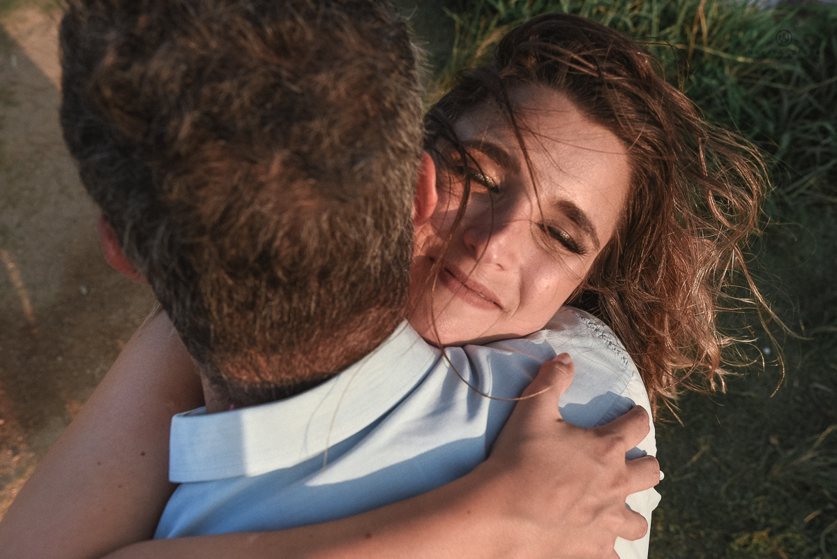 ensaio feito no fim de tarde na praia com a golden hour lindos raios de sol e luz natural casal romantico e apaixonado