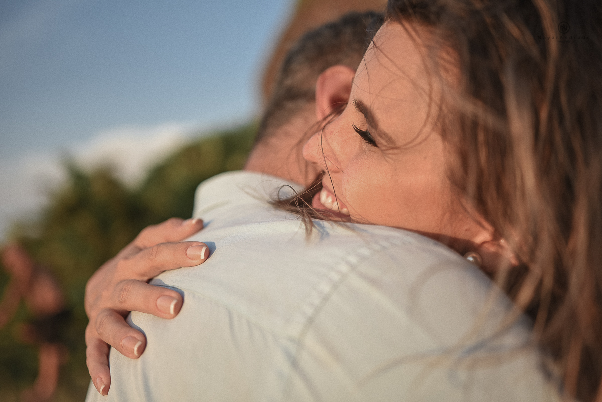 ensaio feito no fim de tarde na praia com a golden hour lindos raios de sol e luz natural casal romantico e apaixonado