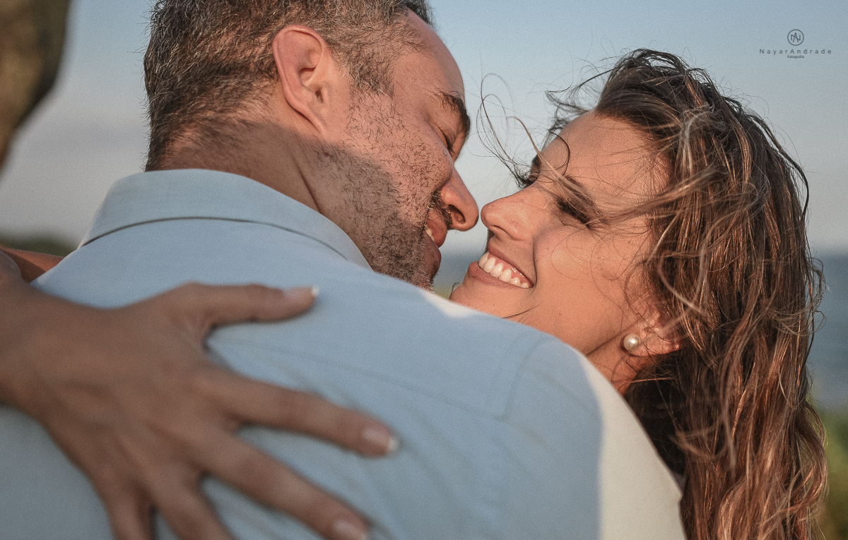 ensaio feito no fim de tarde na praia com a golden hour lindos raios de sol e luz natural casal romantico e apaixonado