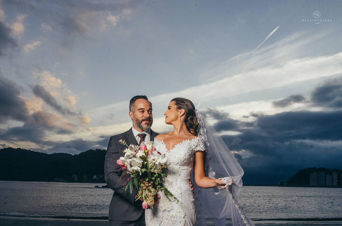 fotos externas feitas em sao vicente santos na subida do ilha porchat com o por do sol casal vestidos de noivo na praia