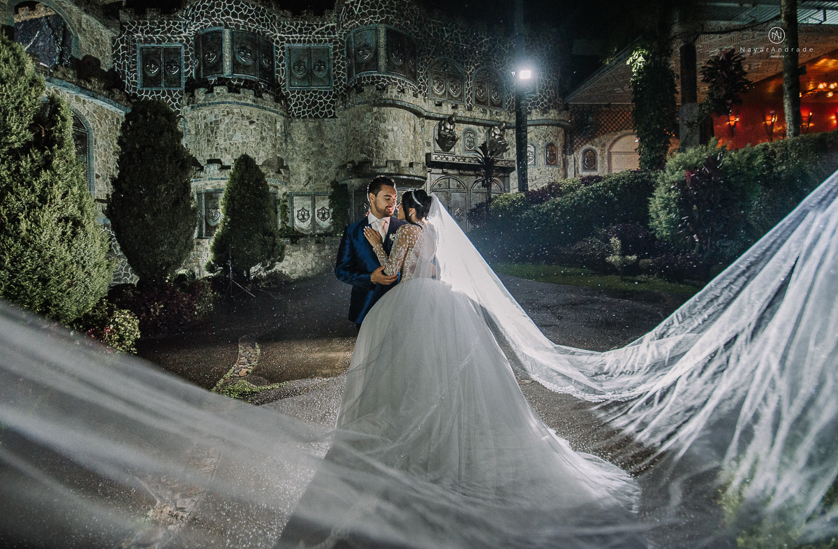 casamento feito em um castelo noiva com vestido de princesa e noivo com terno azul, fotos posadas externas no castelo com chuva fotografia nayara andrade