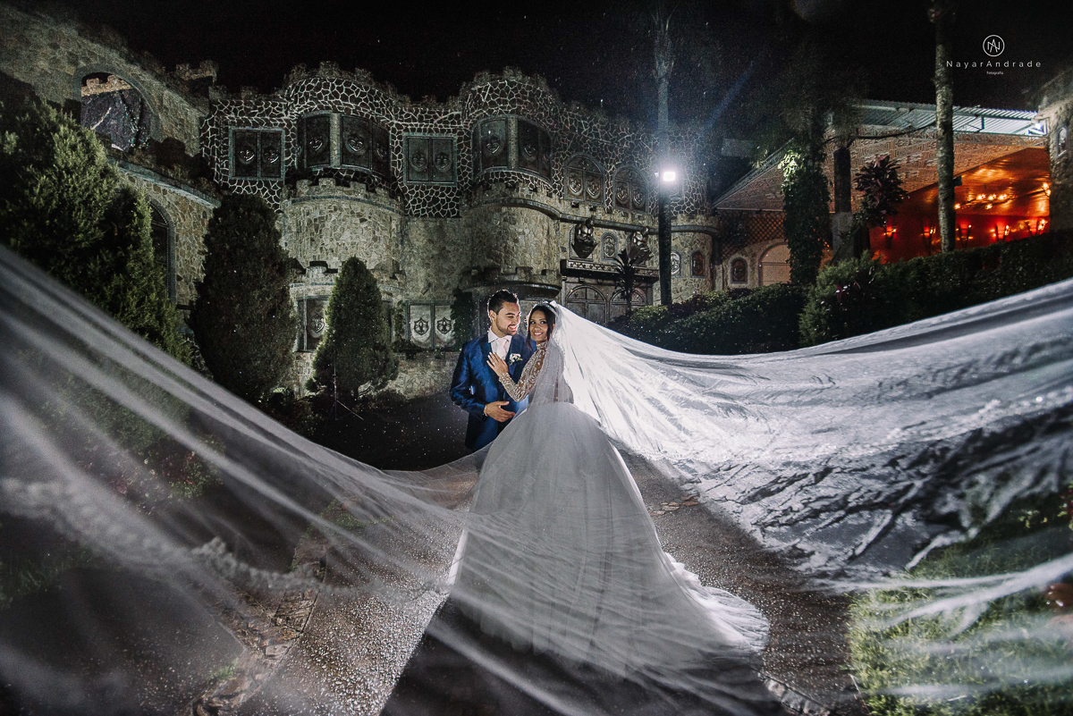 casamento feito em um castelo noiva com vestido de princesa e noivo com terno azul, fotos posadas externas no castelo com chuva fotografia nayara andrade