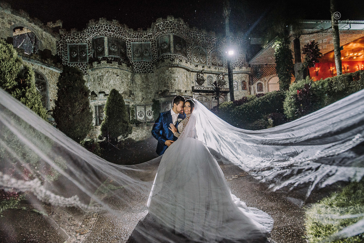 casamento feito em um castelo noiva com vestido de princesa e noivo com terno azul, fotos posadas externas no castelo com chuva fotografia nayara andrade