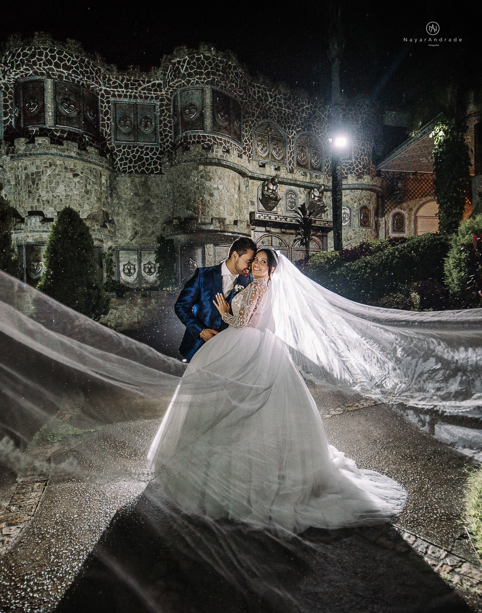 casamento feito em um castelo noiva com vestido de princesa e noivo com terno azul, fotos posadas externas no castelo com chuva fotografia nayara andrade
