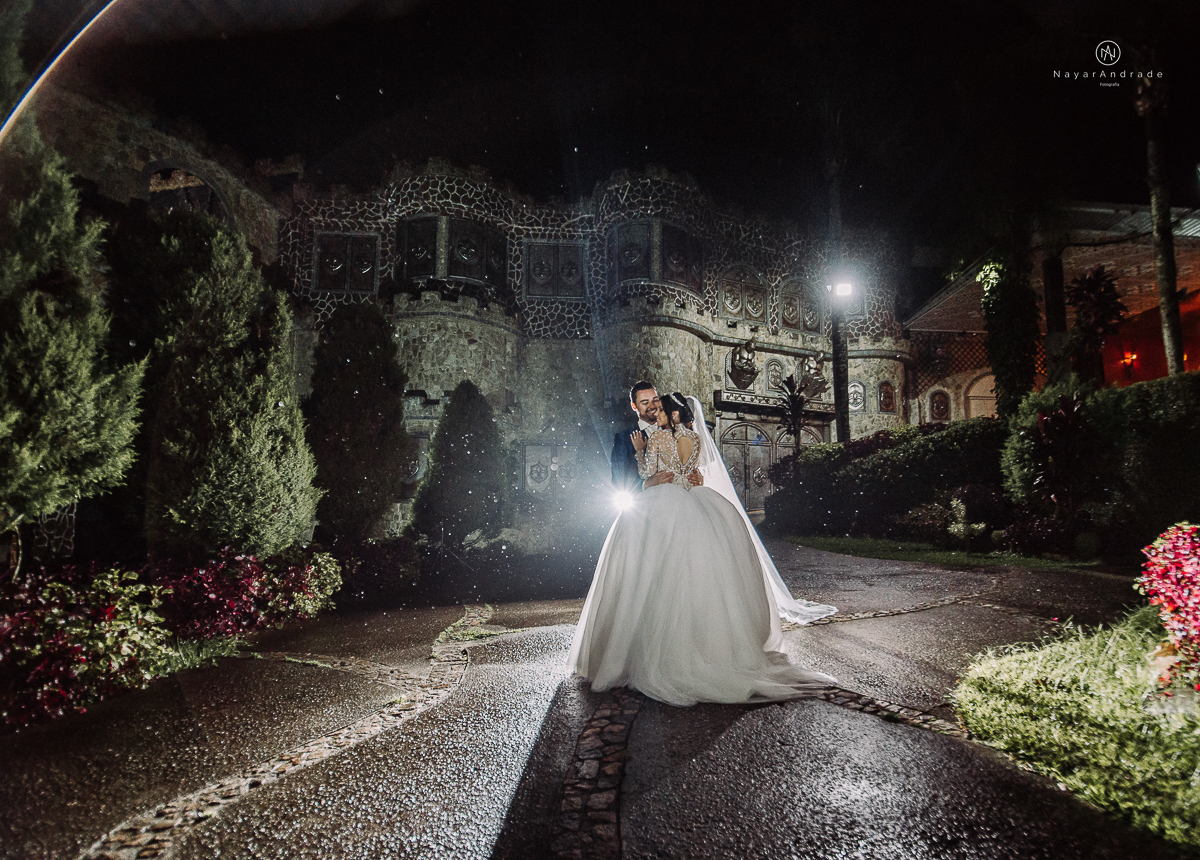 casamento feito em um castelo noiva com vestido de princesa e noivo com terno azul, fotos posadas externas no castelo com chuva fotografia nayara andrade
