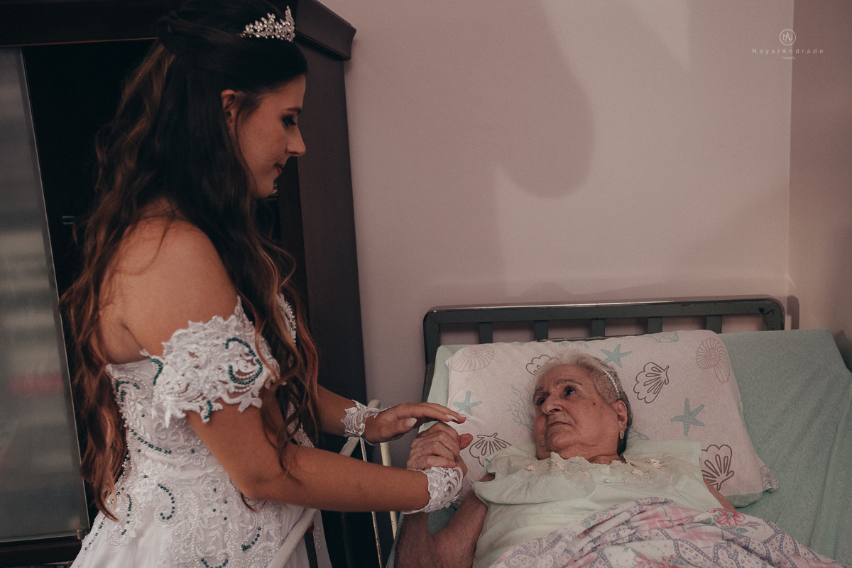 Foto da noiva indo ver a avó antes de casar. A avó esta deitada na cama foto emocionante de neta com avó