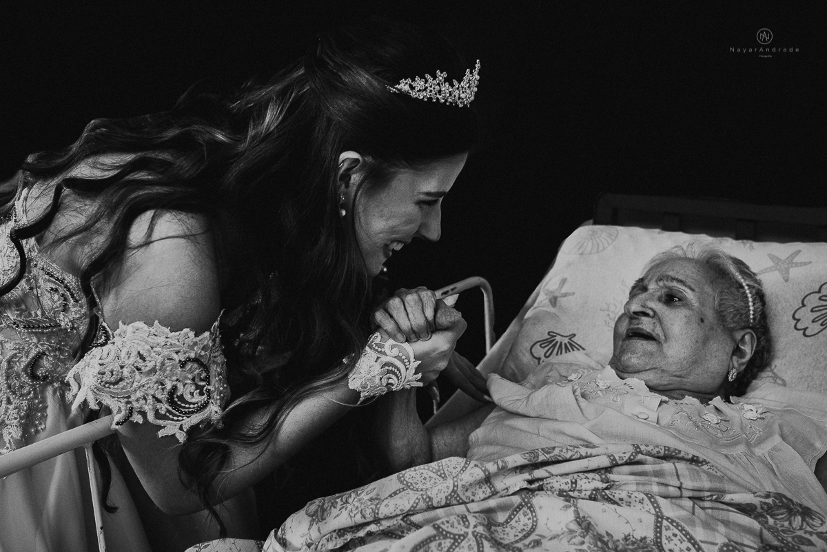 Foto da noiva indo ver a avó antes de casar. A avó esta deitada na cama foto emocionante de neta com avó