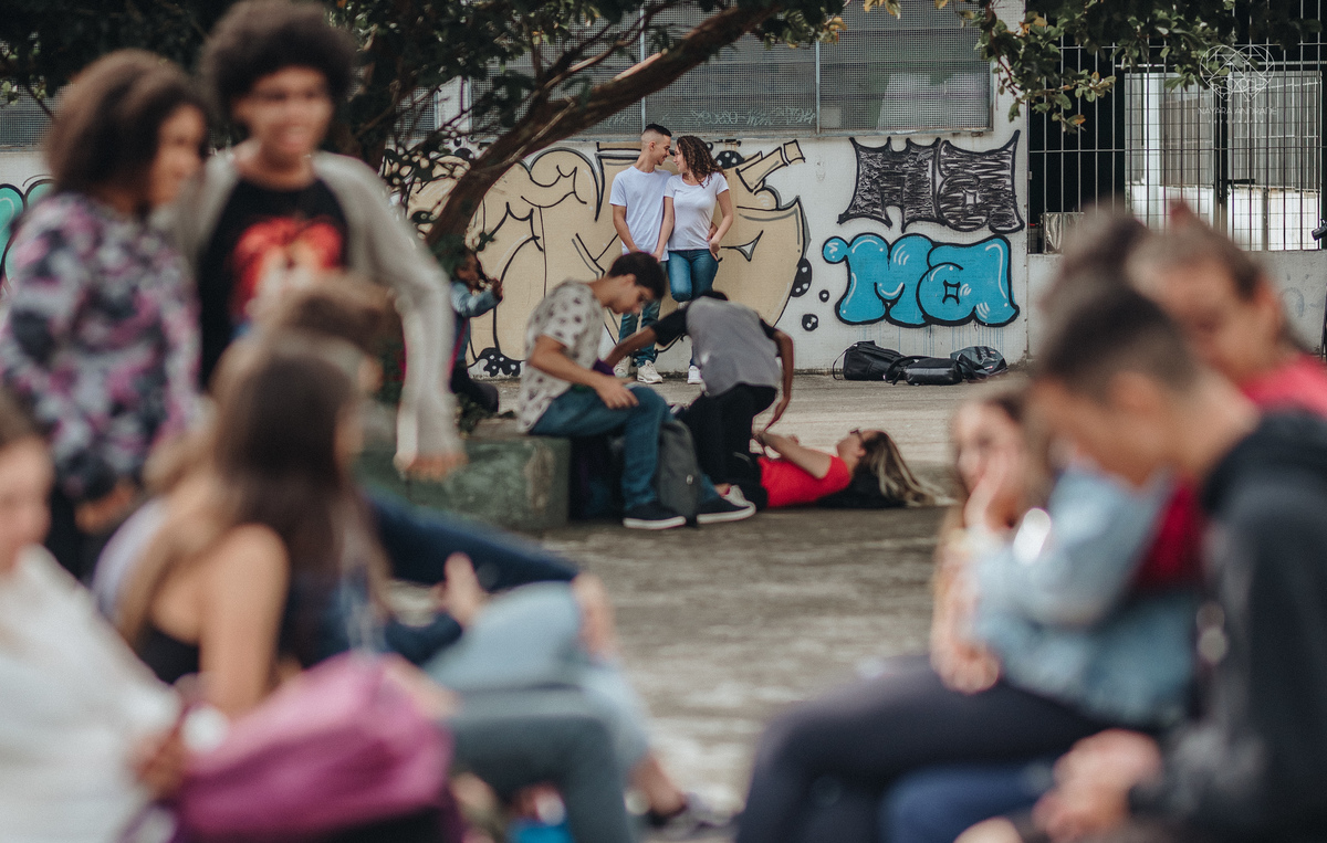 Ensaio pre wedding ensaio casal feito na escola com uniforme escolar blusa branca e calça jeans com uniforme da escola em dia de aula. Local onde tudo começou amor de escola ensaio fotos book casal