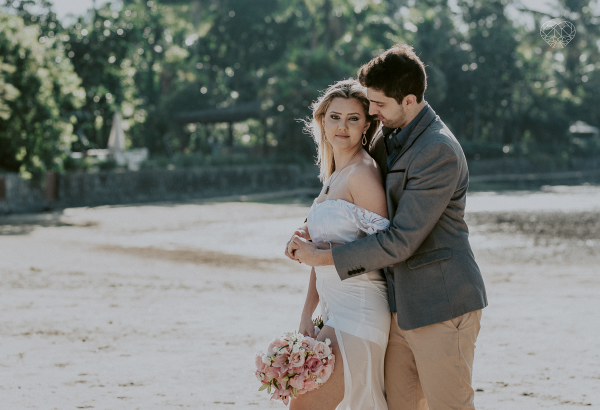 ensaio pre casamento pre wedding na praia das conchas no guaruja melhor fotografa noiva de roupa branca e buque e noivo com roupa sociall fotos feitas na agua  na grama e correndo nas pedras ensaio feito pela fotografa premiada nayara andrade de santos
