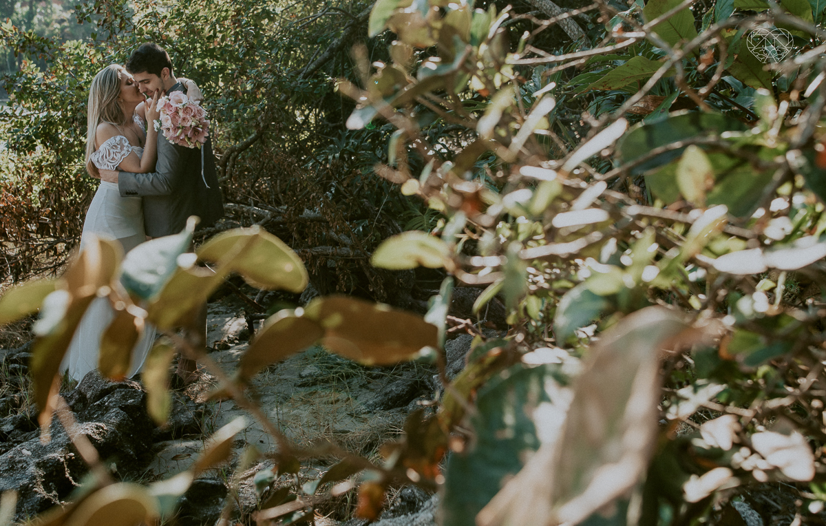 ensaio pre casamento pre wedding na praia das conchas no guaruja noiva de roupa branca e buque e noivo com roupa sociall fotos feitas na agua  na grama e correndo nas pedras ensaio feito pela fotografa premiada nayara andrade de santos