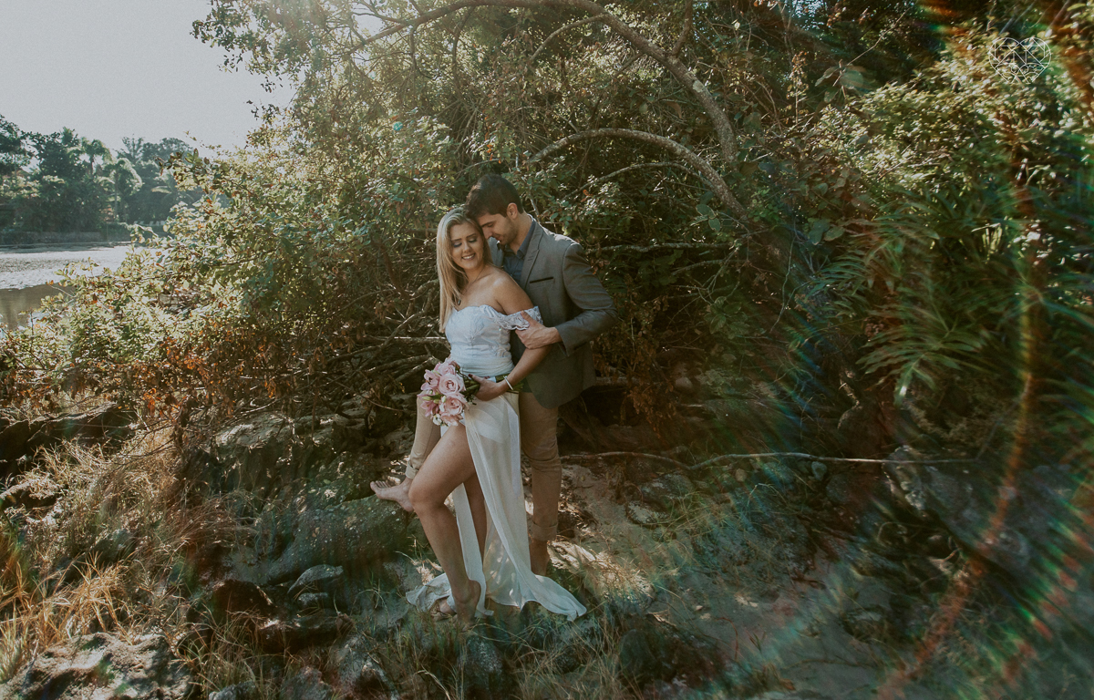 ensaio pre casamento pre wedding na praia das conchas melhor fotografa no guaruja noiva de roupa branca e buque e noivo com roupa sociall fotos feitas na agua  na grama e correndo nas pedras ensaio feito pela fotografa premiada nayara andrade de santos