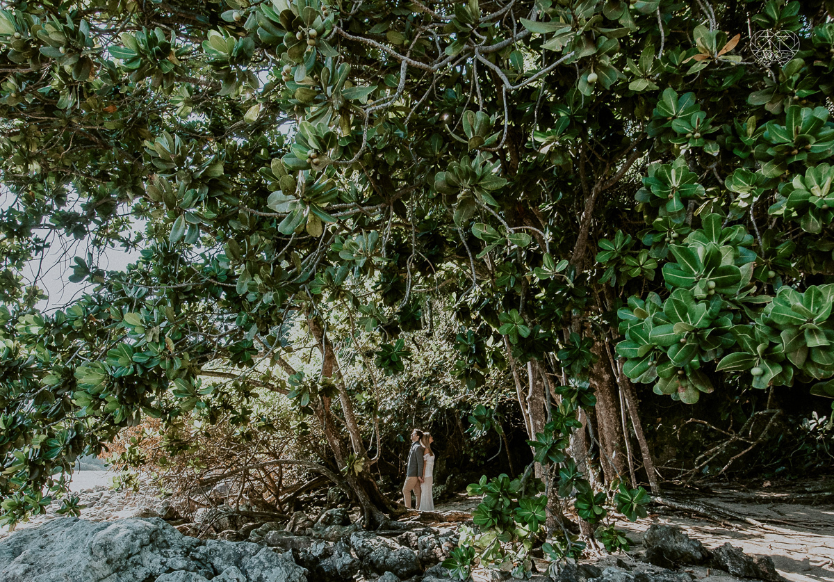 ensaio pre casamento pre wedding na praia das conchas no guaruja noiva de roupa branca e buque e noivo com roupa sociall fotos feitas na agua  na grama e correndo nas pedras ensaio feito pela fotografa premiada nayara andrade de santos