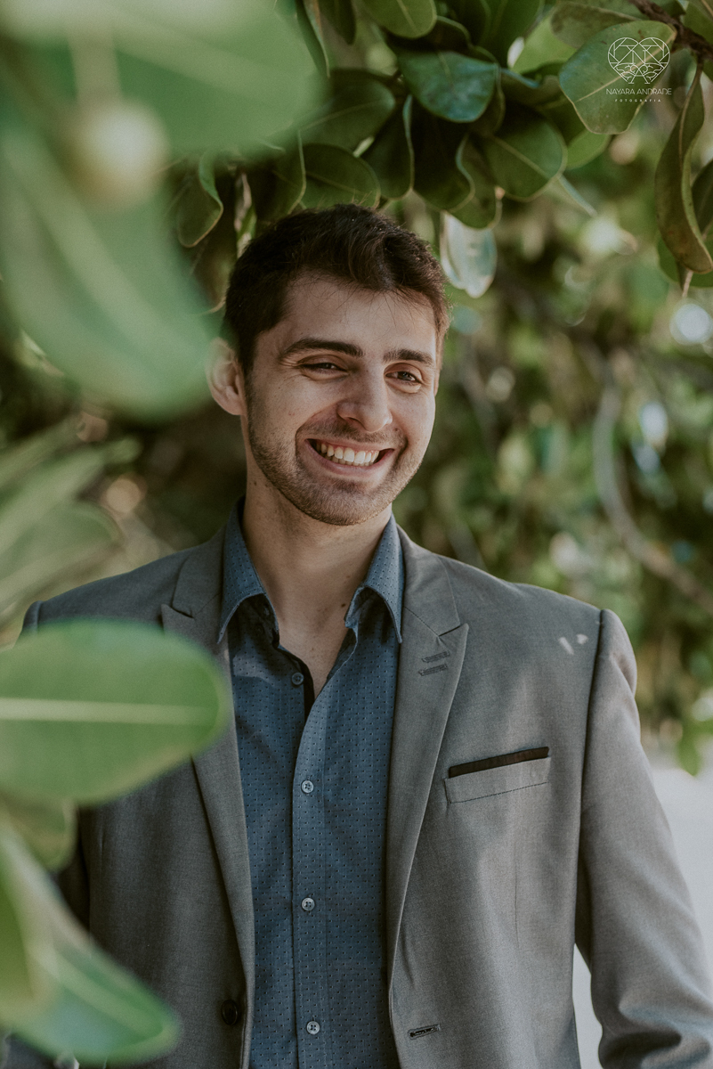 ensaio pre casamento pre wedding na praia das conchas no guaruja noiva de roupa branca e buque e noivo com roupa sociall fotos feitas na agua  na grama e correndo nas pedras ensaio feito pela fotografa premiada nayara andrade de santos