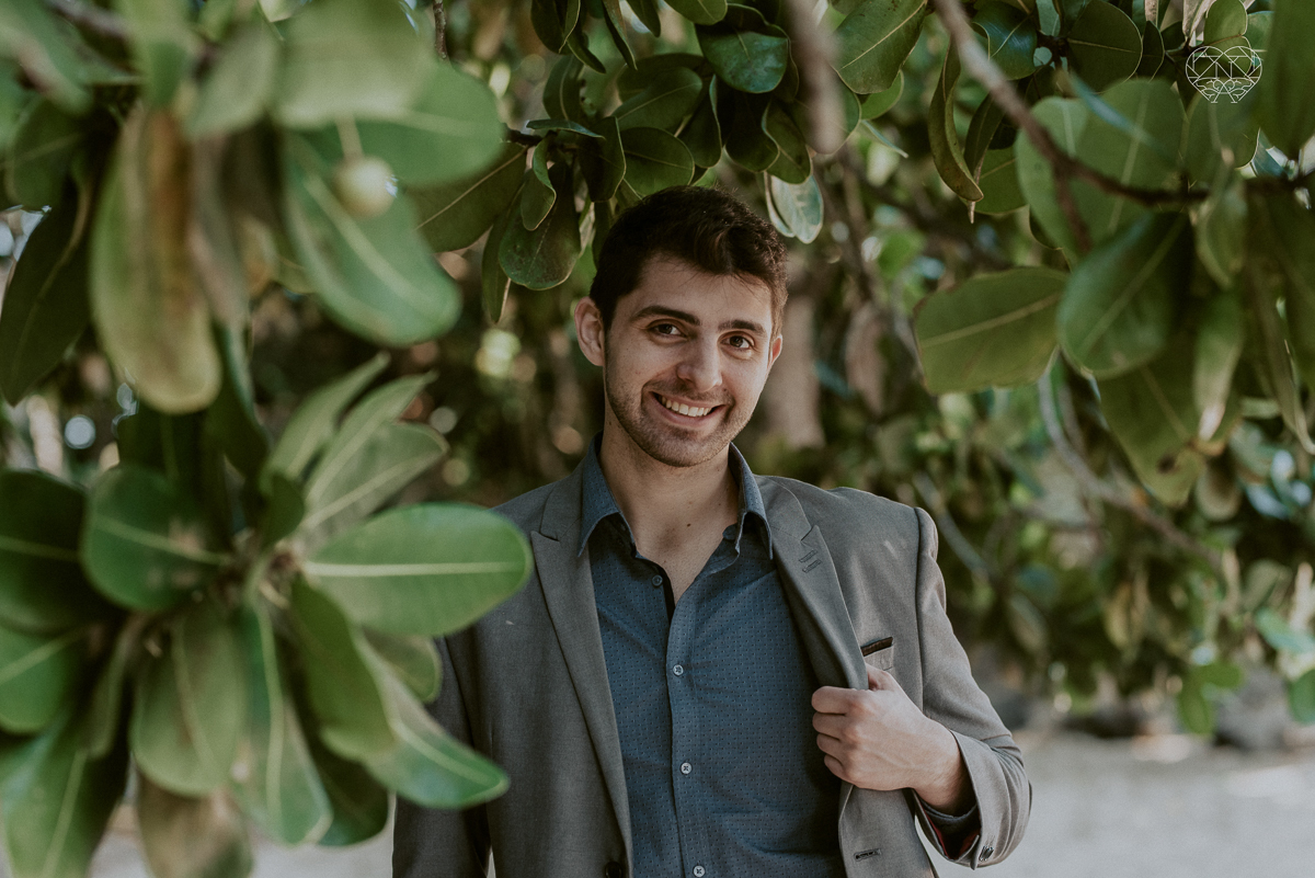 ensaio pre casamento pre wedding na praia das conchas no guaruja noiva de roupa branca e buque e noivo com roupa sociall fotos feitas na agua  na grama e correndo nas pedras ensaio feito pela fotografa premiada nayara andrade de santos