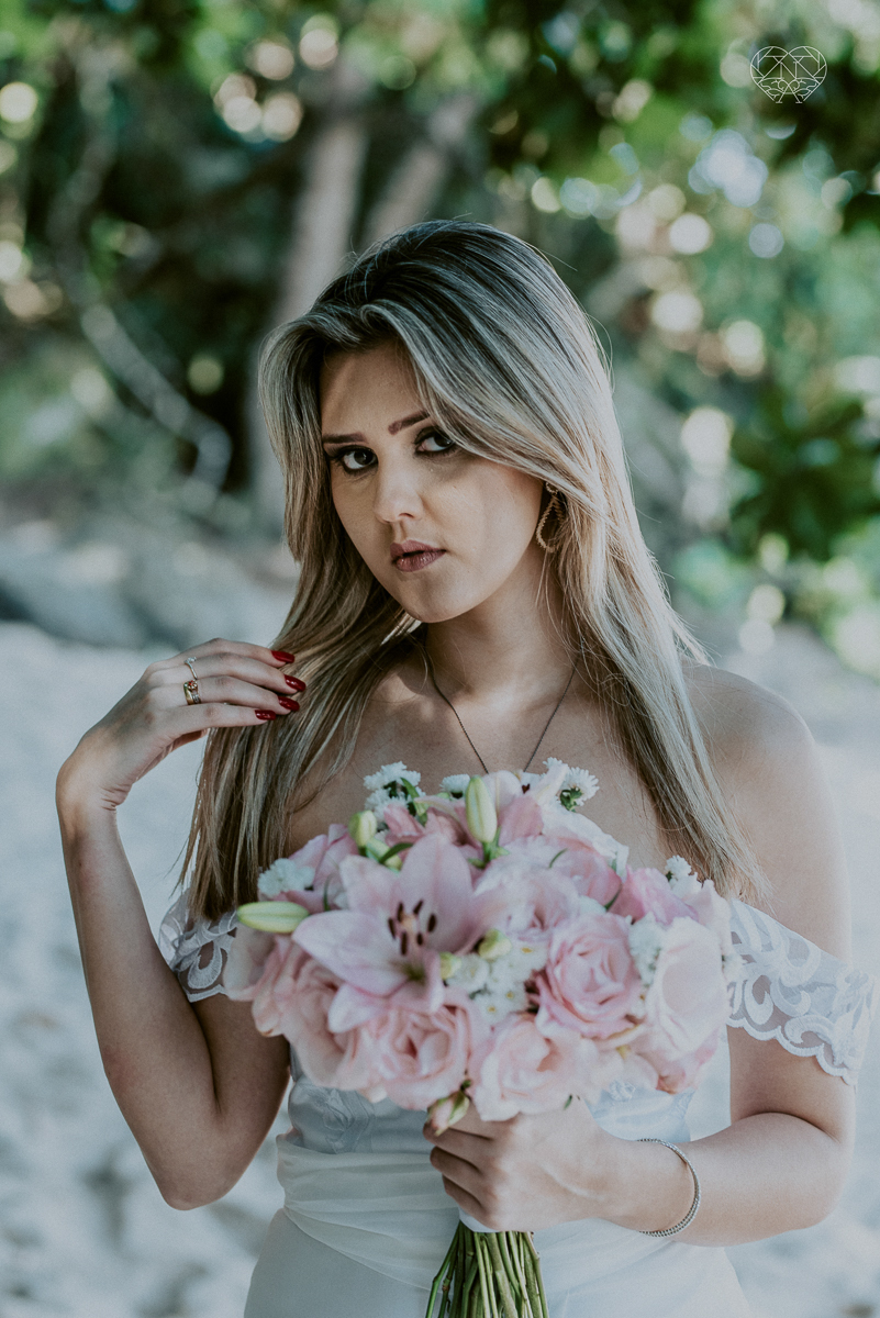 ensaio pre casamento pre wedding na praia das conchas no guaruja noiva de roupa branca e buque e noivo com roupa sociall fotos feitas na agua  na grama e correndo nas pedras ensaio feito pela fotografa premiada nayara andrade de santos