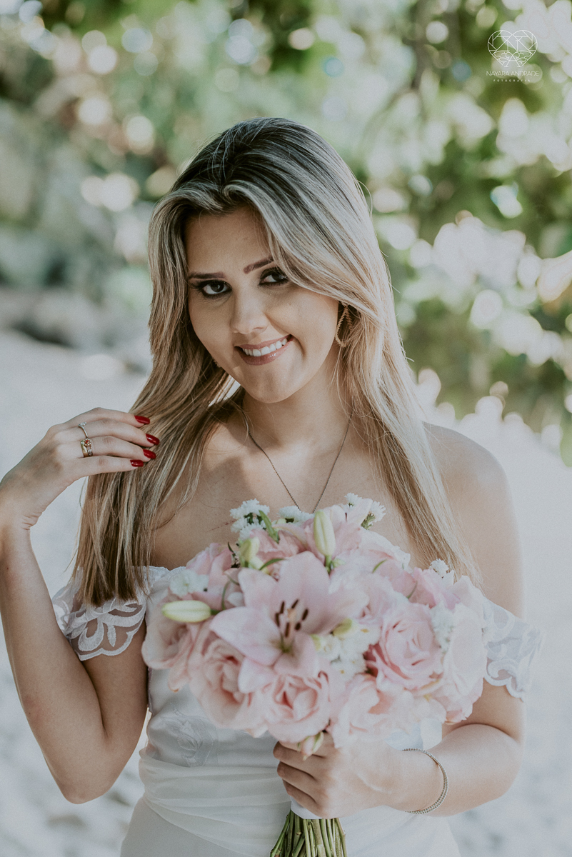 ensaio pre casamento pre wedding na praia das conchas no guaruja noiva de roupa branca e buque e noivo com roupa sociall fotos feitas na agua  na grama e correndo nas pedras ensaio feito pela fotografa premiada nayara andrade de santos