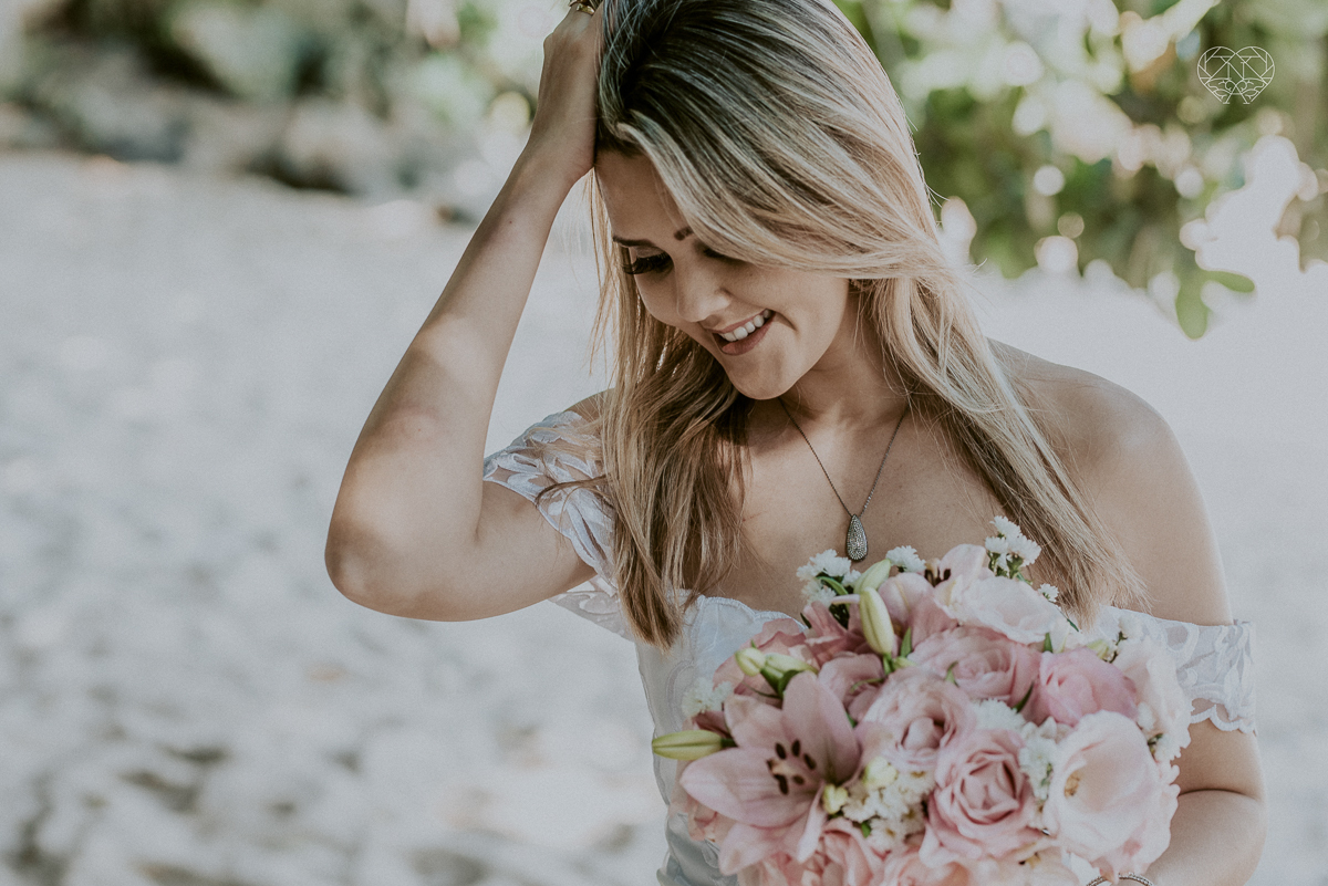 ensaio pre casamento pre wedding na praia das conchas no guaruja noiva de roupa branca e buque e noivo com roupa sociall fotos feitas na agua  na grama e correndo nas pedras ensaio feito pela fotografa premiada nayara andrade de santos