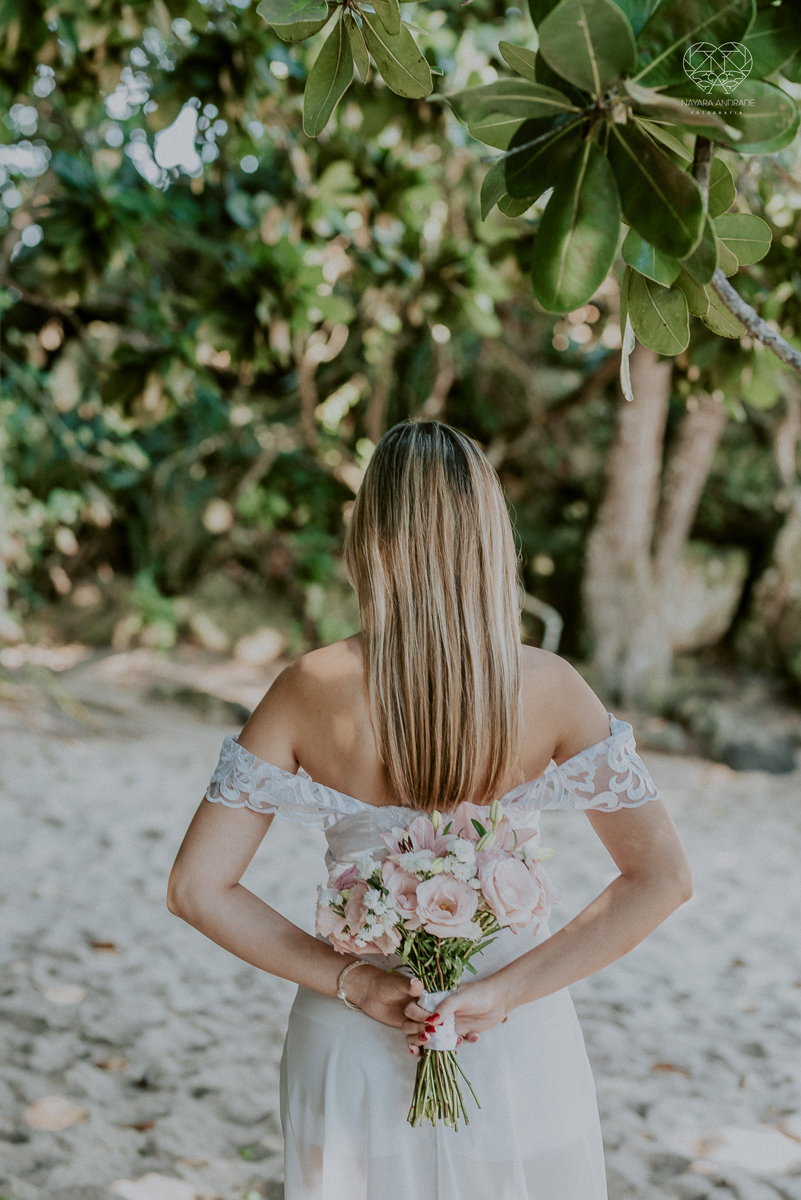 ensaio pre casamento pre wedding na praia das conchas no guaruja noiva de roupa branca e buque e noivo com roupa sociall fotos feitas na agua  na grama e correndo nas pedras ensaio feito pela fotografa premiada nayara andrade de santos