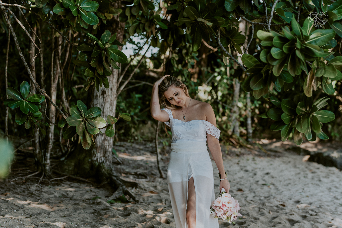 ensaio pre casamento pre wedding na praia das conchas no guaruja noiva de roupa branca e buque e noivo com roupa sociall fotos feitas na agua  na grama e correndo nas pedras ensaio feito pela fotografa premiada nayara andrade de santos