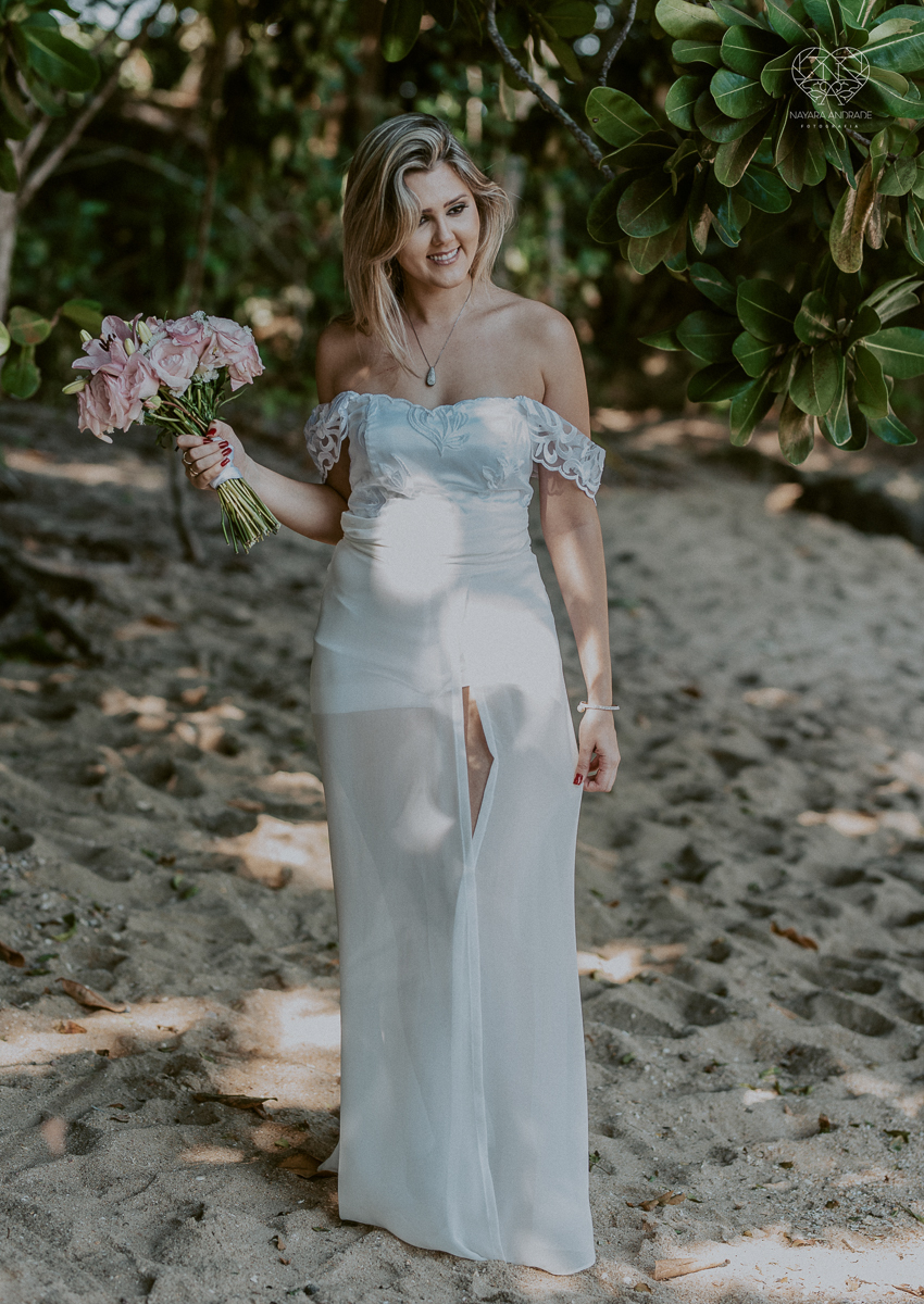 ensaio pre casamento pre wedding na praia das conchas no guaruja noiva de roupa branca e buque e noivo com roupa sociall fotos feitas na agua  na grama e correndo nas pedras ensaio feito pela fotografa premiada nayara andrade de santos