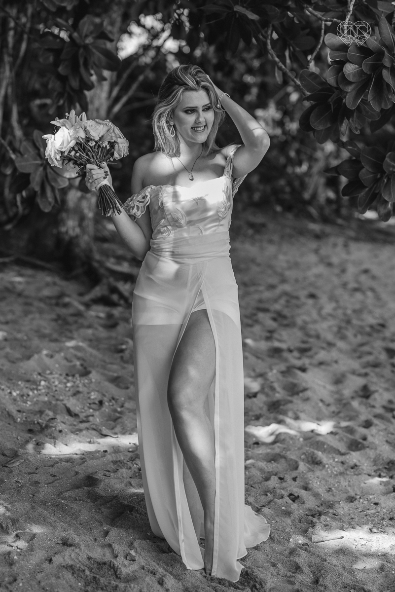 ensaio pre casamento pre wedding na praia das conchas no guaruja noiva de roupa branca e buque e noivo com roupa sociall fotos feitas na agua  na grama e correndo nas pedras ensaio feito pela fotografa premiada nayara andrade de santos