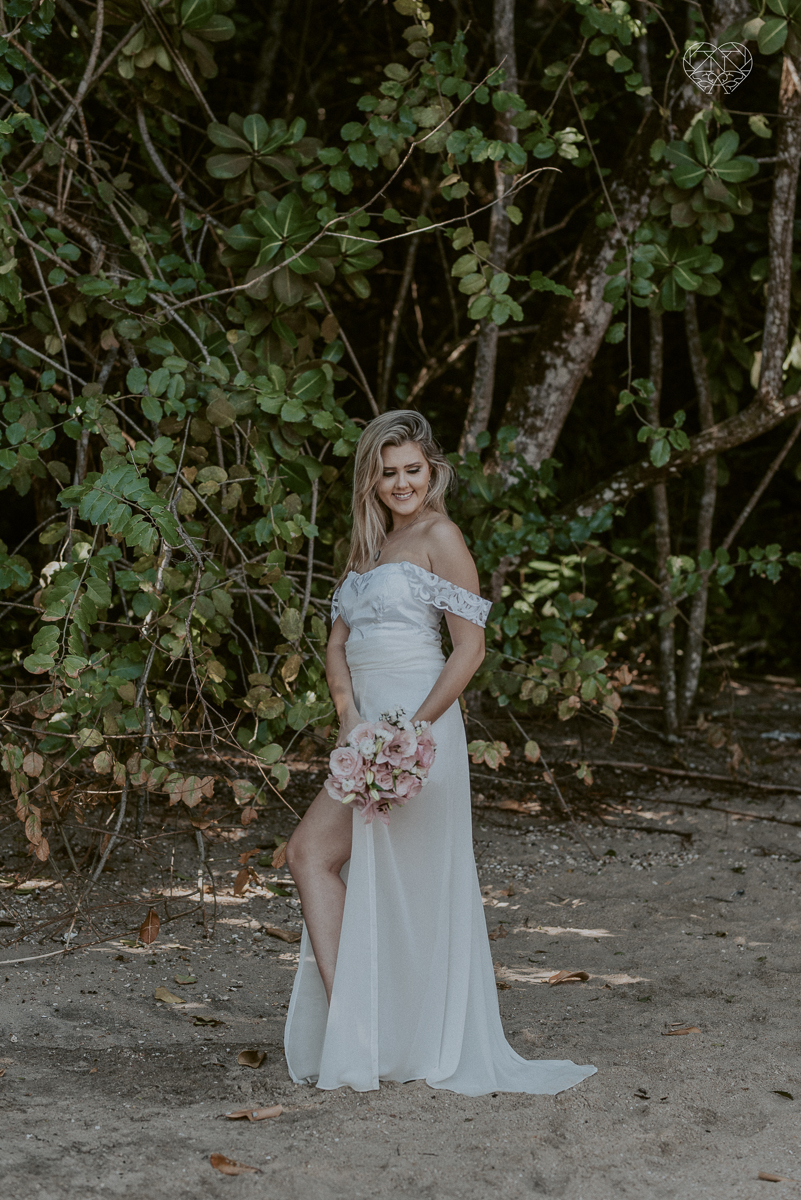 ensaio pre casamento pre wedding na praia das conchas no guaruja noiva de roupa branca e buque e noivo com roupa sociall fotos feitas na agua  na grama e correndo nas pedras ensaio feito pela fotografa premiada nayara andrade de santos