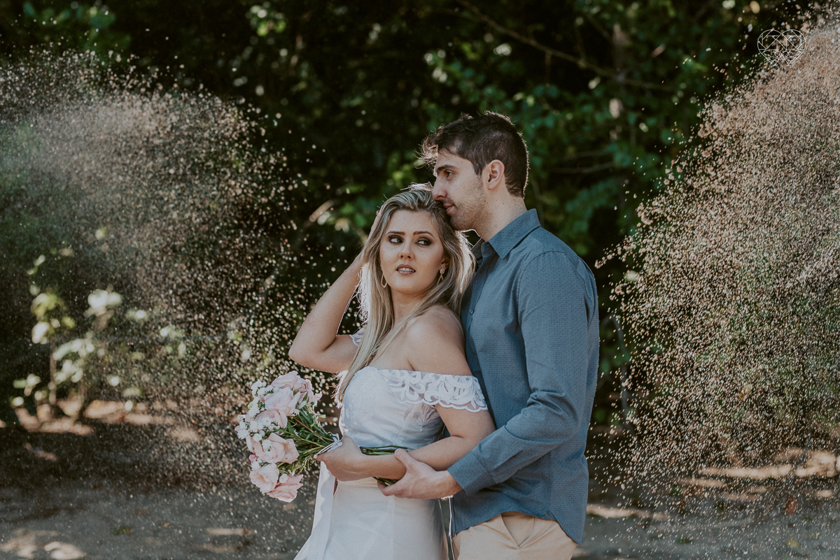 ensaio pre casamento pre wedding na praia das conchas no guaruja noiva de roupa branca e buque e noivo com roupa sociall fotos feitas na agua  na grama e correndo nas pedras ensaio feito pela fotografa premiada nayara andrade de santos