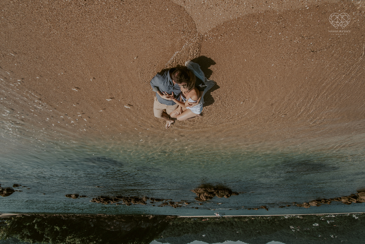 ensaio pre casamento pre wedding na praia das  melhor fotografa conchas no guaruja noiva de roupa branca e buque e noivo com roupa sociall fotos feitas na agua  na grama e correndo nas pedras ensaio feito pela fotografa premiada nayara andrade de santos