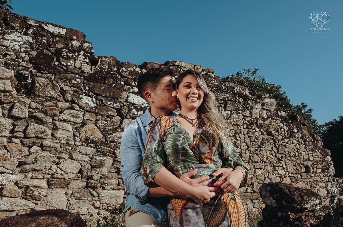 Ensaio pre wedding de casal japones niponico feito em itariri em sao paulo pela fotografa premiada nayara andrade. Noivo de camisa jeans e noiva de roupa florida