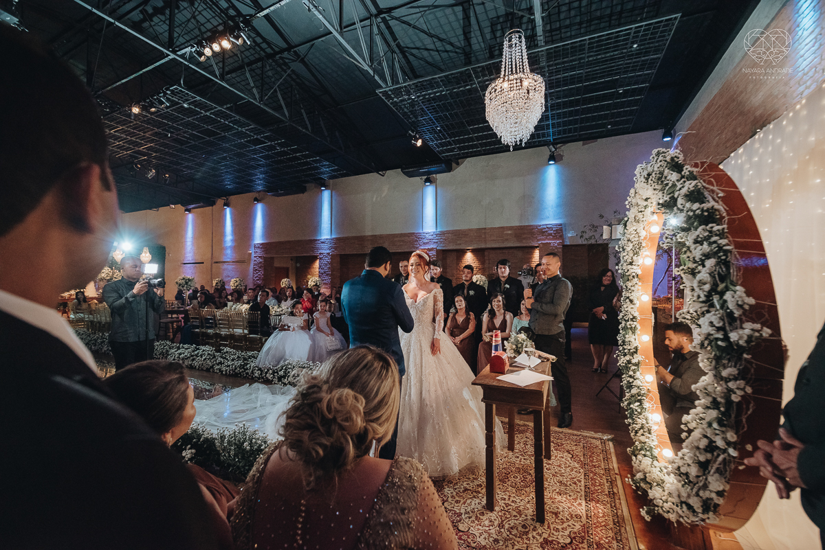 cerimonia realizada no salao atmosfera em guaruja com decoraçao classica e flores brancas noiva vestida de princesa e noivo de terno azul nfotografia com a fotografa premiada nayara andrade