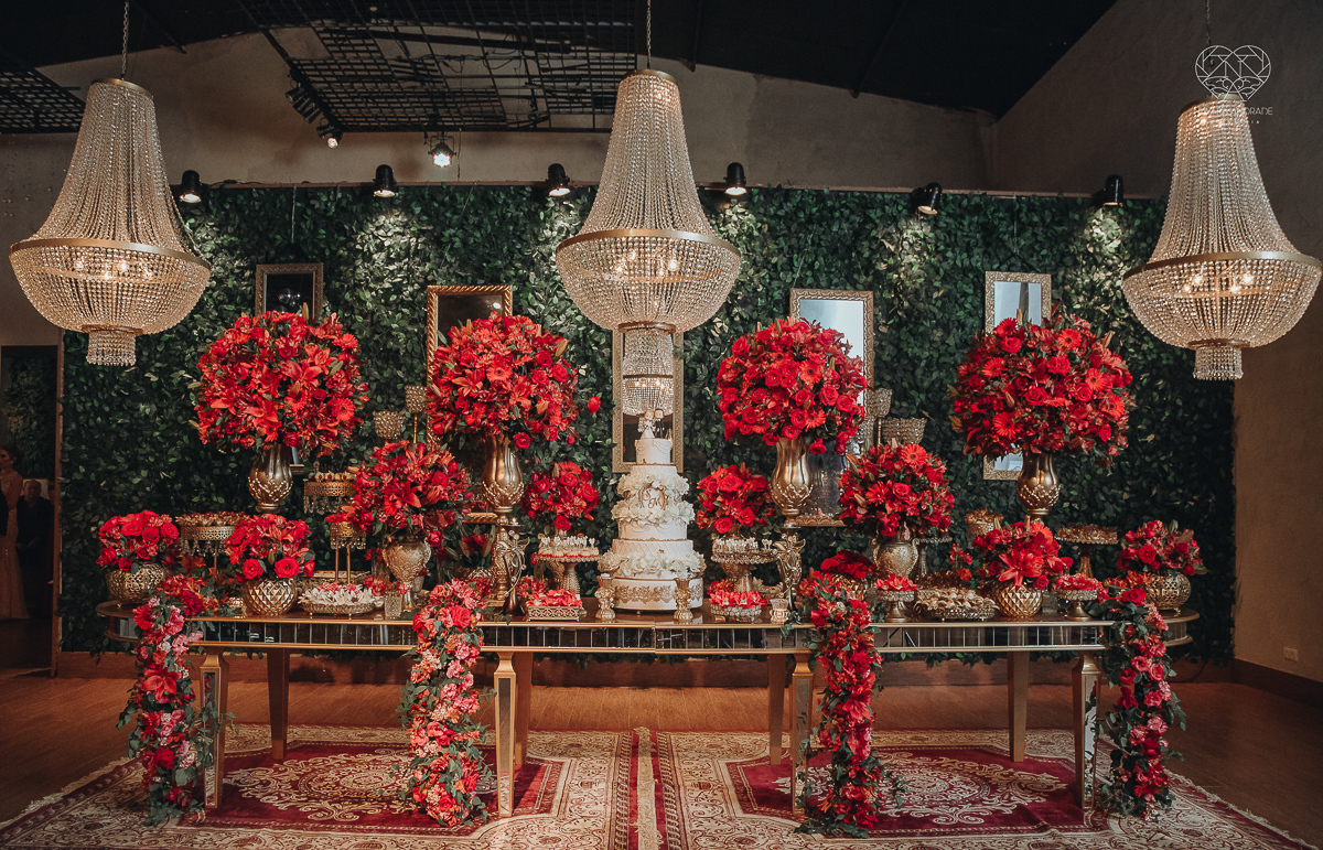 decoraçao de casamento classico com flores vermelhas, lustre, arranjos caidos na mesa, espaco atmosphera feita por lu pallaroni