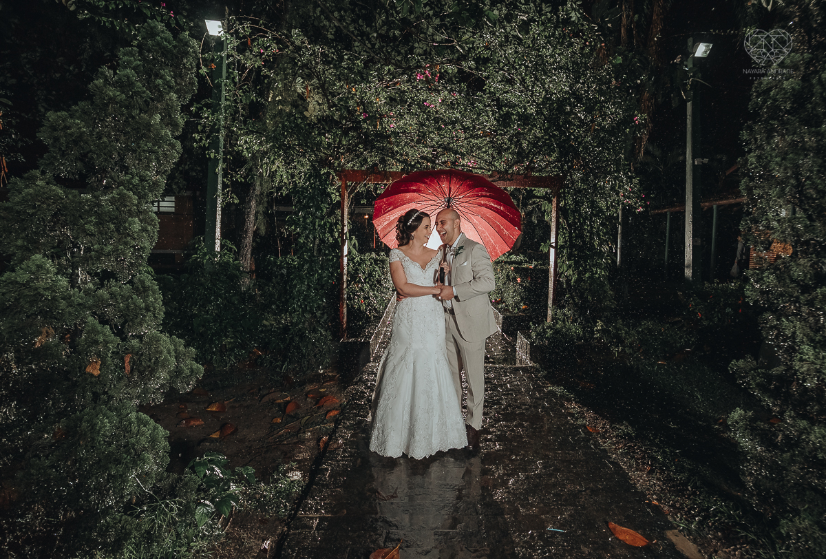 casamento rustico de dia com chuva em santos sao vicente golf clube noivo com terno bege e noiva com vestido de renda fotos da fotografa premiada nayara andrade  fotos externas na chuva com guarda chuva de casamento