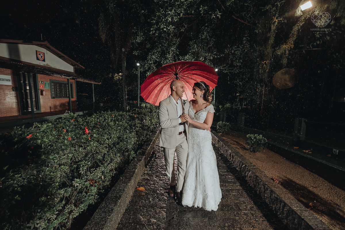 casamento rustico de dia com chuva em santos sao vicente golf clube noivo com terno bege e noiva com vestido de renda fotos da fotografa premiada nayara andrade  fotos externas na chuva com guarda chuva de casamento