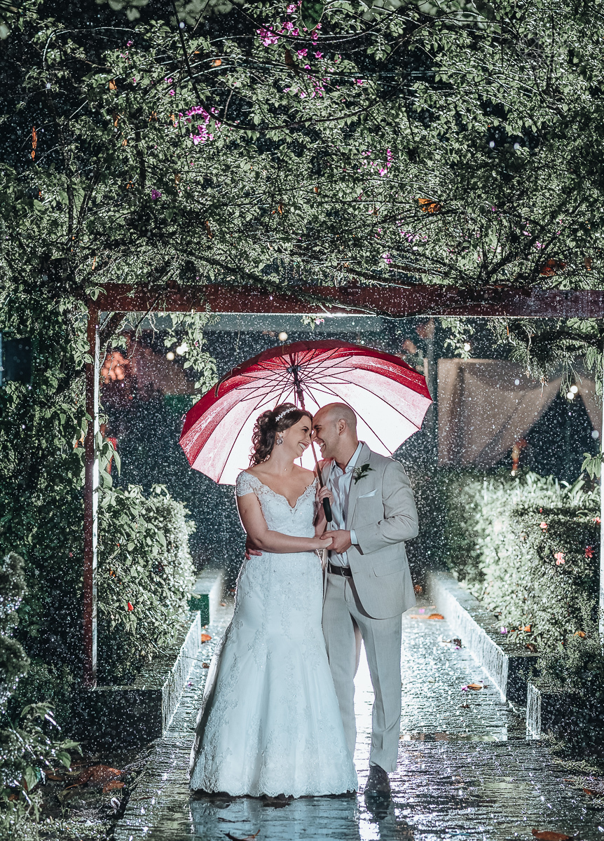 casamento rustico de dia com chuva em santos sao vicente golf clube noivo com terno bege e noiva com vestido de renda fotos da fotografa premiada nayara andrade  fotos externas na chuva com guarda chuva de casamento