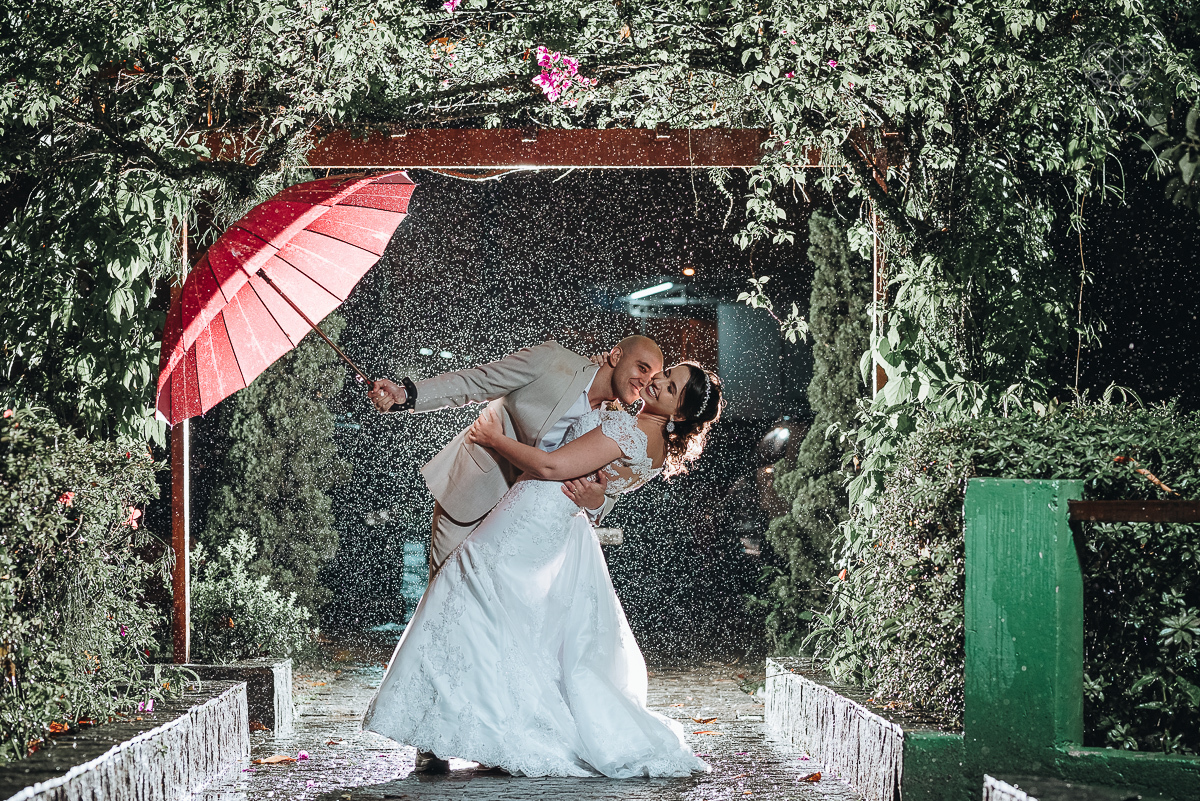 casamento rustico de dia com chuva em santos sao vicente golf clube noivo com terno bege e noiva com vestido de renda fotos da fotografa premiada nayara andrade  fotos externas na chuva com guarda chuva de casamento