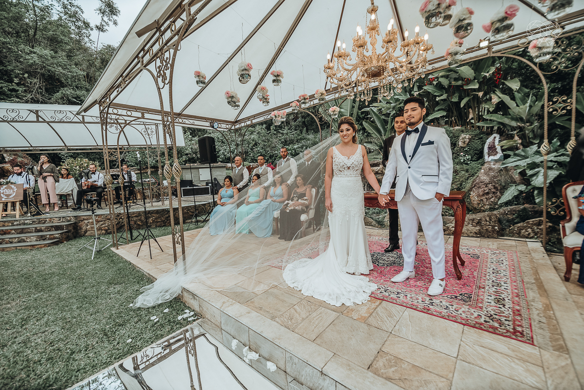 casamento de dia no ravena garden ao ar livre noivo com roupa branca noiva com mantilha fotos pela fotografa premiada nayara andrade de santos casamento com passarela espelhada