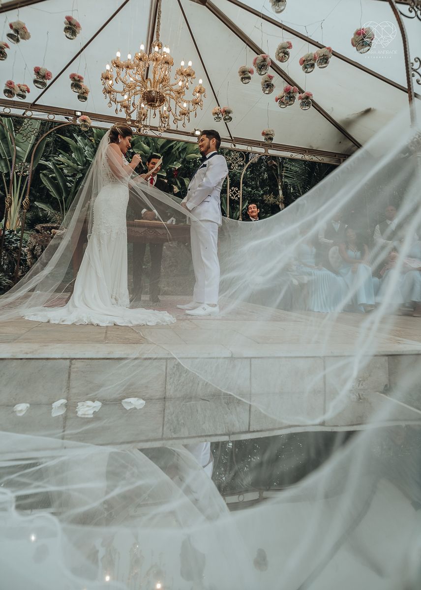 casamento de dia no ravena garden ao ar livre noivo com roupa branca noiva com mantilha fotos pela fotografa premiada nayara andrade de santos casamento com passarela espelhada