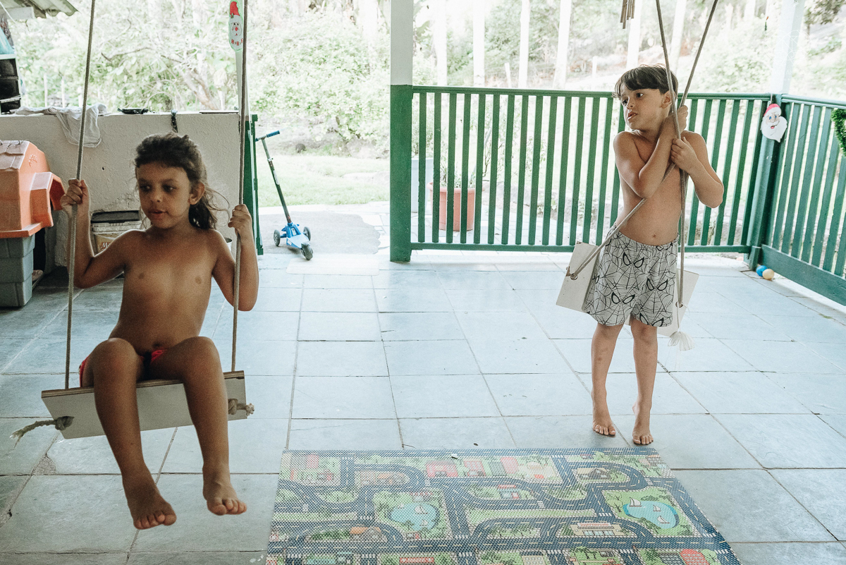 ensaio familia lifestyle brincando de mangueira no quintal de casa com o papai crianças e o cachorro fotografado pela fotografa premiada nayara andrade nayara andrade fotografia