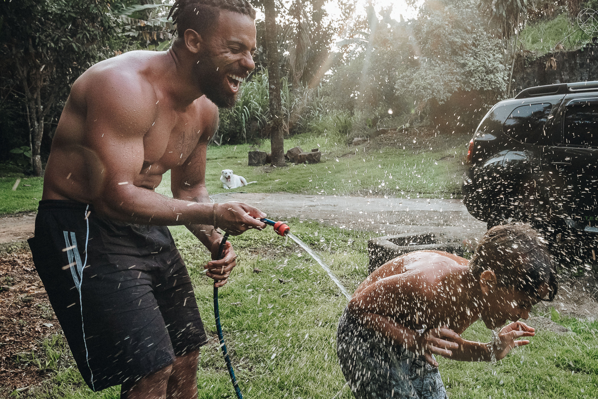 ensaio familia lifestyle brincando de mangueira no quintal de casa com o papai crianças e o cachorro fotografado pela fotografa premiada nayara andrade nayara andrade fotografia