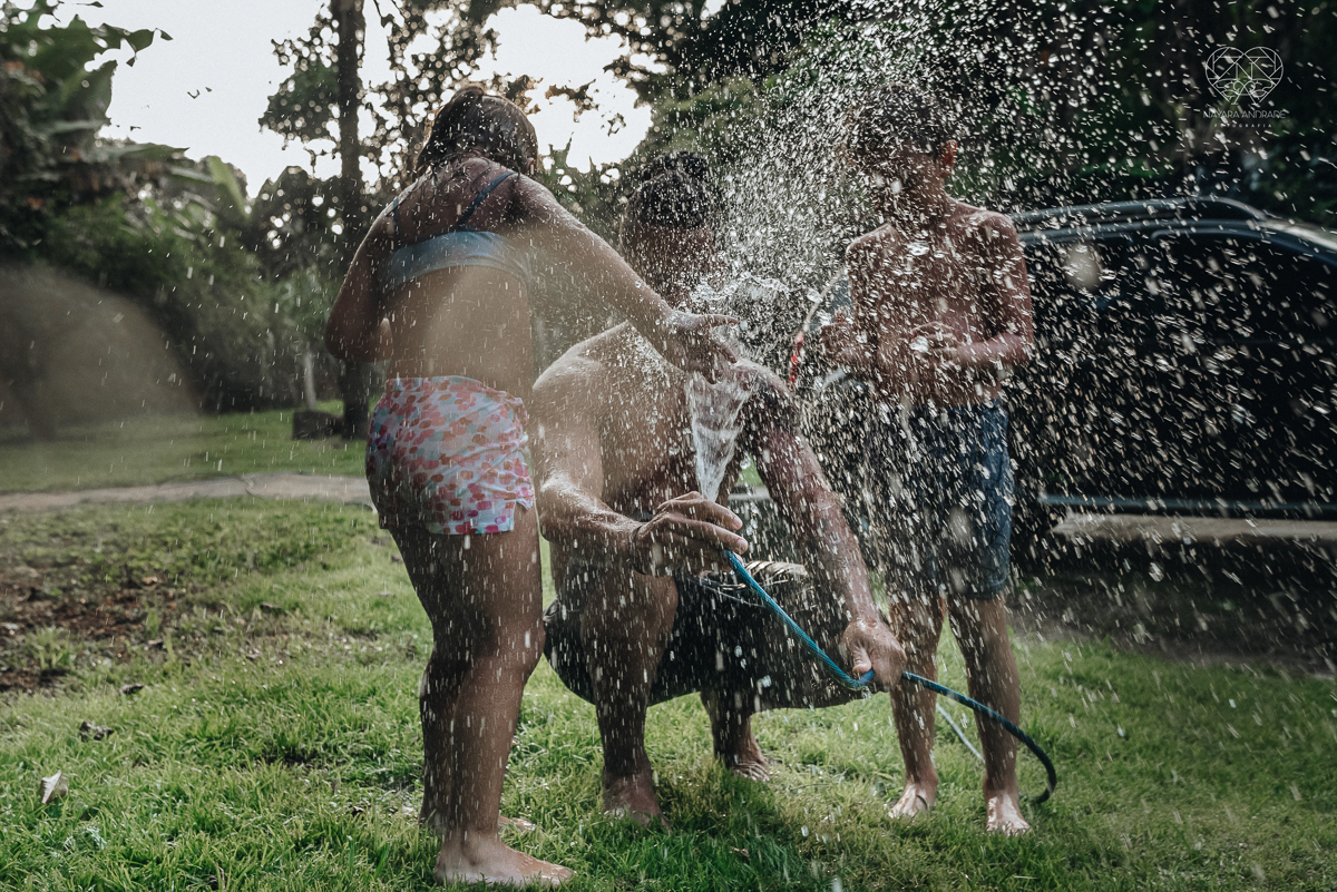 ensaio familia lifestyle brincando de mangueira no quintal de casa com o papai crianças e o cachorro fotografado pela fotografa premiada nayara andrade nayara andrade fotografia