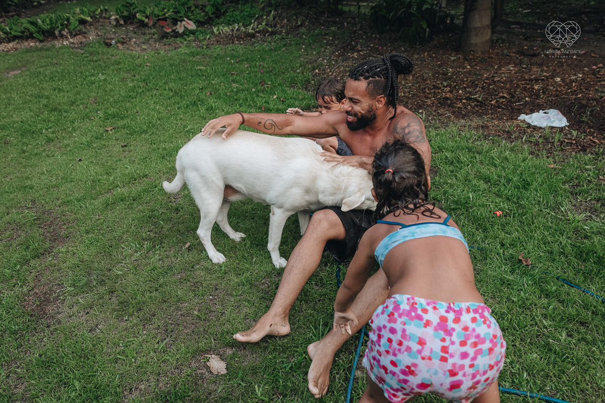 ensaio familia lifestyle brincando de mangueira no quintal de casa com o papai crianças e o cachorro fotografado pela fotografa premiada nayara andrade nayara andrade fotografia