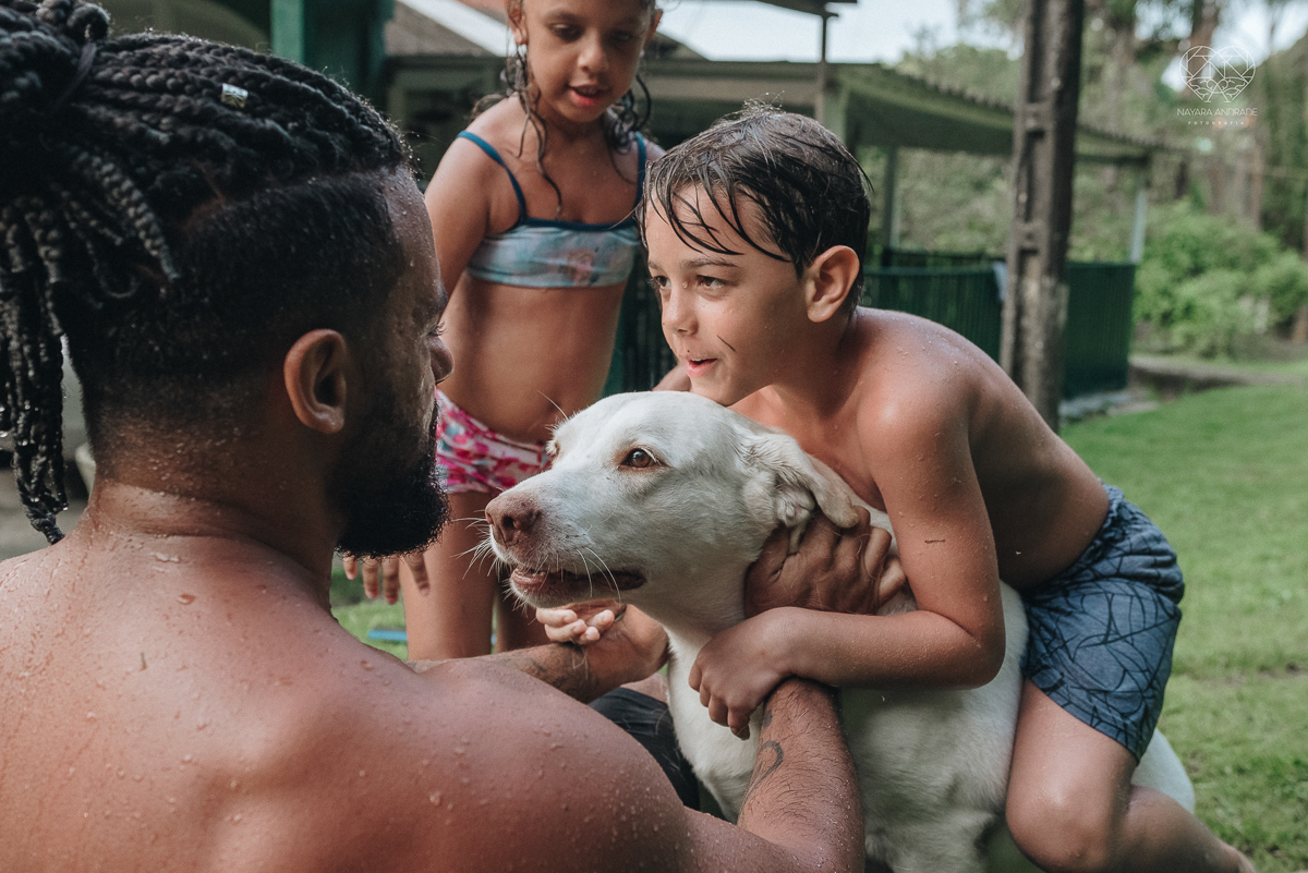 ensaio familia lifestyle brincando de mangueira no quintal de casa com o papai crianças e o cachorro fotografado pela fotografa premiada nayara andrade nayara andrade fotografia